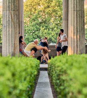 a group of people sitting on a bench by Norbert Braun courtesy of Unsplash.