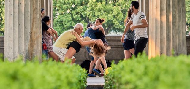 a group of people sitting on a bench by Norbert Braun courtesy of Unsplash.